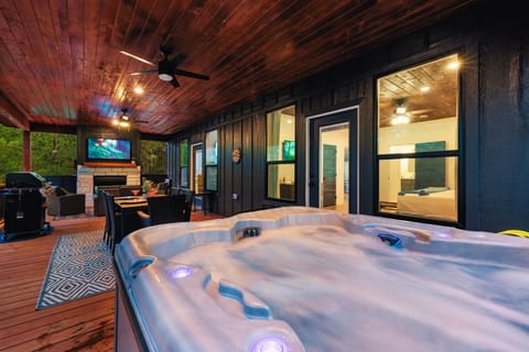 The outdoor patio features a hot tub, dining area, and living area