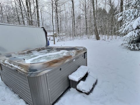 Enjoy a private outdoor hot tub surrounded by peaceful winter scenery.