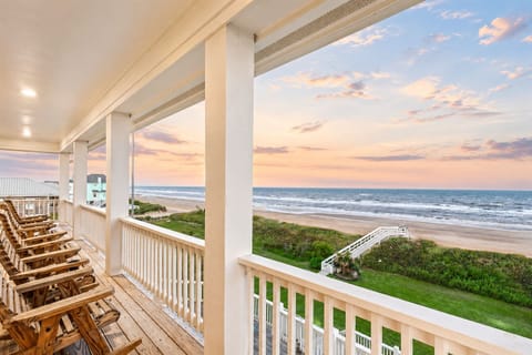 Gulf-front balcony with rocking chairs and panoramic Crystal Beach sunrise views at Brint Drive, Bolivar Peninsula TX. Spacious covered deck perfect for relaxing beachfront vacations.