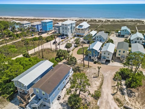Beachfront vacation rental community with colorful coastal homes just steps from pristine sandy shores and crystal-clear waters.