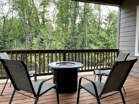 Private deck with fire pit and forest view.