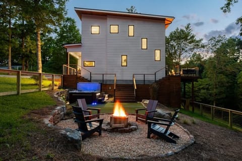 A peek at your private retreat. The firepit, hot tub, and cozy outdoor setup create the perfect space to unwind while taking in the beauty of the home and yard