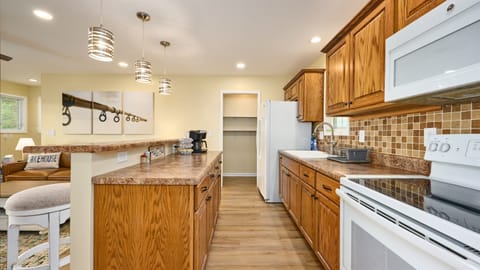 The upper level Kitchen includes a Keurig coffee maker that will brew a whole pot using coffee filters or one cup at time using coffee pods. There is a full size electric range and microwave. There is a large walk-in pantry next to the Refrigerator.