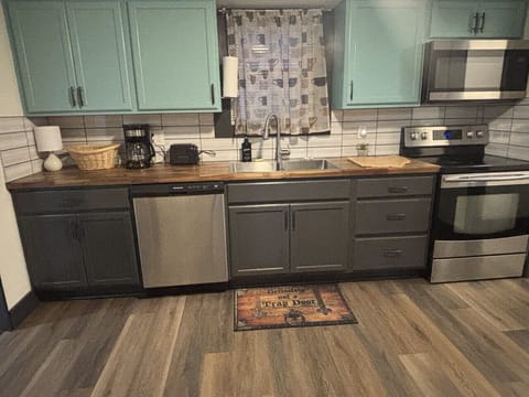 Bright kitchen featuring butcher block counters, stainless range, and open flow to the dining area.