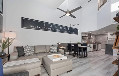 Modern open-concept living area with high ceilings and a cozy sectional sofa.