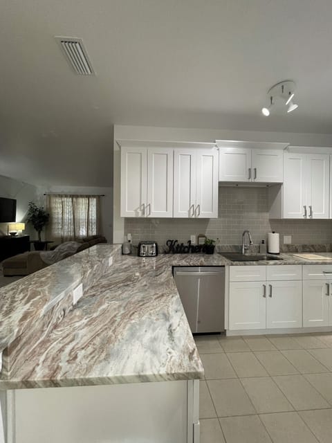 Kitchen light switch left of toaster by the breakfast bar.