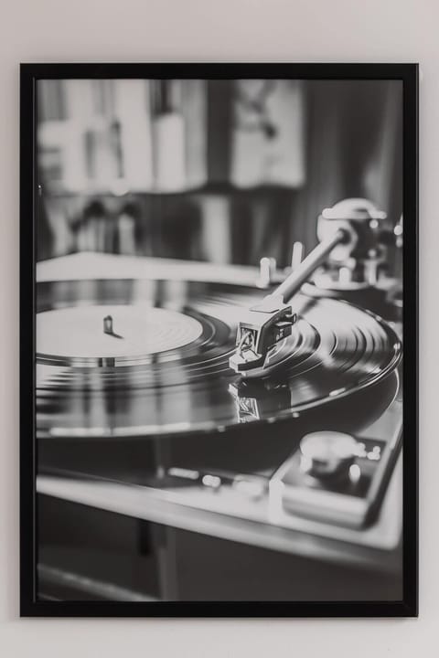 A bedroom with a monochrome framed photograph and subtle lighting. Modern and artistic ambiance.


