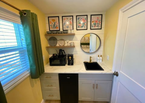 Kitchenette (no range) features micro,frig,coffee, dinnerware, & floral art. 