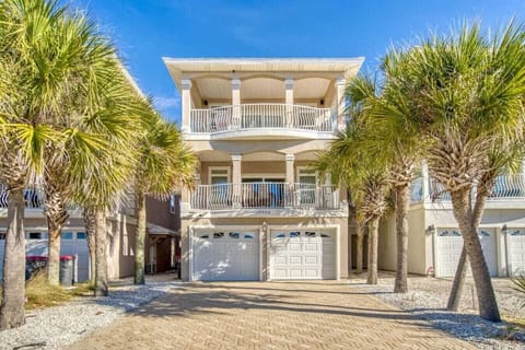Stunning beachside property featuring elegant balconies and tropical palm trees under brilliant blue skies.