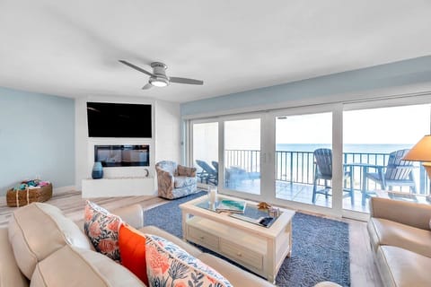 Bright living room w/ cozy seating & large windows that bring in plenty of natural light.