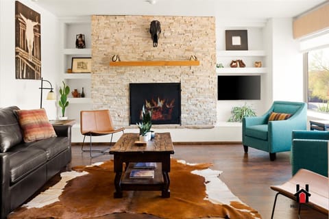 Relax in this luxurious living room by the stone wall fireplace