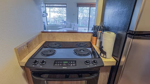 [Kitchen] Galley kitchen includes oven, fridge, dishwasher, microwave, pots/pans