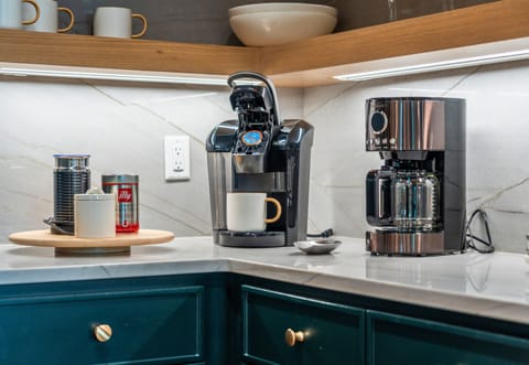 Start your day right with a fresh cup of coffee from this well-equipped kitchen corner. The stylish appliances and thoughtful design make it a perfect spot for your morning routine.