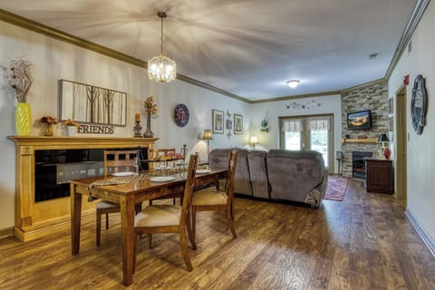Living Room, Dining Table, Chairs, Brick Fireplace, Hardwood Floors, Art, Decor.
