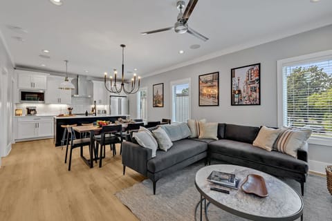 (Unit 1) 2nd Floor: Cozy and welcoming open-concept living area effortlessly integrates the stylishly furnished living room with the fully equipped kitchen and dining space.