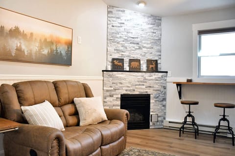 Comfortable living area with a reclining sofa, gas fireplace, and sky light, perfect for unwinding after a day of mountain adventures.