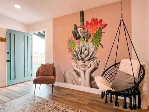 Beautiful mural and hanging chair at the entrance of the home.