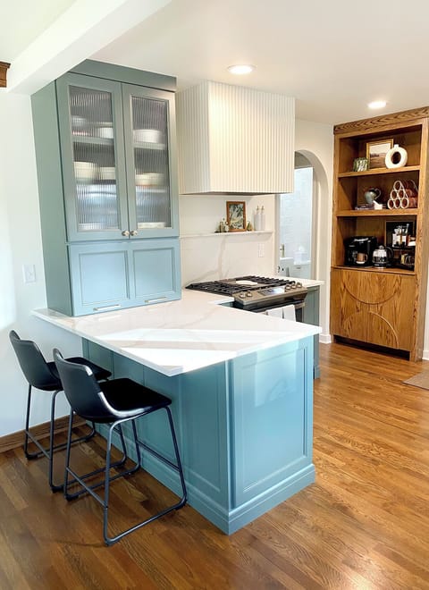 A convenient counter with bar stools offers a perfect area for snacks.