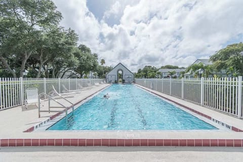 Outdoor pool area with lounge chairs and surrounding greenery