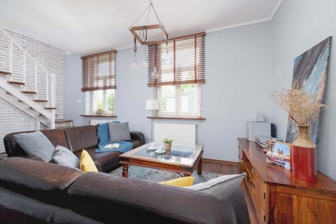 Modern living area featuring a large sectional sofa, hardwood floors, and an open loft staircase—ideal for stylish urban living.