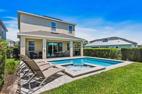Relax in the sunlit private backyard featuring a pristine pool and comfortable lounging chairs.
