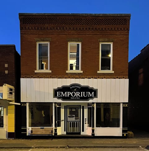Located above the Nauvoo Emporium. The entrance is in the walkway to the right
