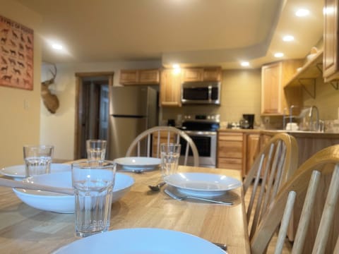 Family style wood table with chairs and a bench. Beautiful dining area, open kitchen floor plan.