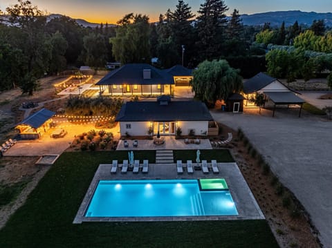 Outdoor Oasis: Stunning poolside retreat surrounded by twinkling lights and lush greenery!