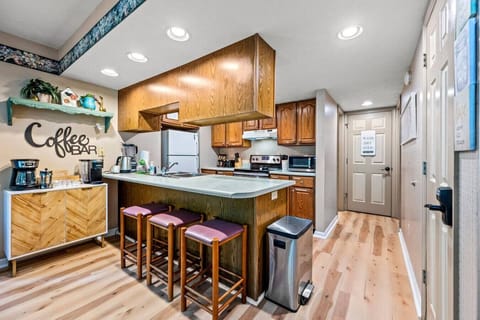 The kitchen includes three bar stools for additional seating at the countertop.
