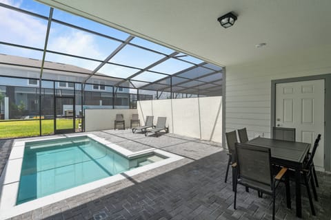 Step outside to enjoy a private oasis with a crystal-clear pool and sleek patio tiles. The spacious area features a modern dining set and loungers, ideal for soaking up the sun in a peaceful atmosphere.
