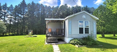 Front of cottage, deck and sitting area, surrounded by 60 to 70 foot pines
