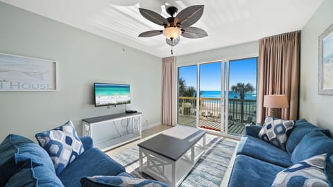 Sink into plush blue sofas while ocean views fill your windows and gentle ceiling fan keeps you cool.