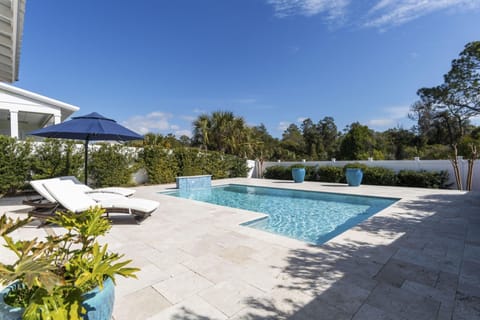 Dive into your private oasis with this sparkling pool surrounded by comfortable loungers and tropical landscaping for ultimate relaxation.