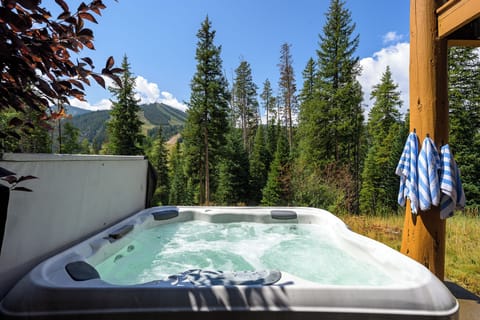 Hot tub with mountain and forest views under open skies   - Relax in bubbling warmth after outdoor adventures nearby   - Peaceful retreat with fresh alpine air and natural beauty