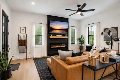 Relaxation awaits in this bright living area featuring chic leather seating, a modern fireplace, and an inviting open layout.