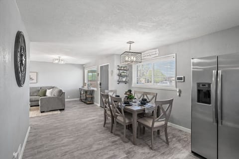 Open dining area w/ modern table set beside the kitchen, ideal for shared meals & conversation.