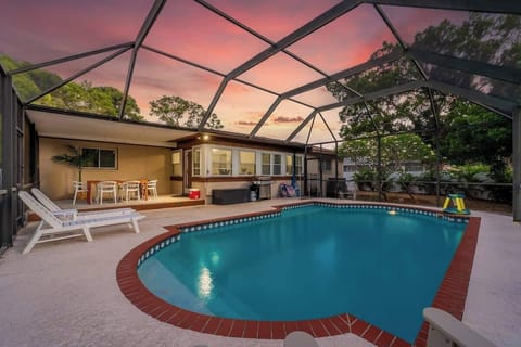 Relax in this beautiful screened-in pool oasis! Sparkling turquoise water, brick-trimmed deck, comfy loungers, and a covered patio for outdoor dining. Perfect for sunset swims, family fun, and bug-free Florida evenings—your private retreat awaits!
