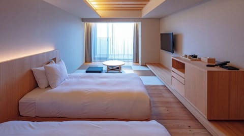 [Standard Twin] 40m² / bed width 1,200mm. A low table is provided in the tatami space by the window.