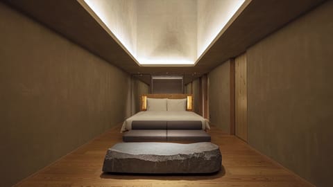[SOKI Suite] 66m² / bed width 1,800mm. Equipped with a sofa and a stone table.