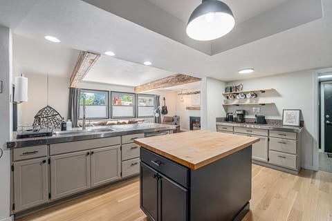 - Fully equipped kitchen featuring a butcher block island and steel countertops
- Wake up to fresh coffee from the sleek barista style setup and open shelving display
- Stay connected with the open concept layout flowing into a bright, comfy living room