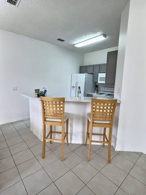 Savor casual dining at the stylish breakfast bar with light wood stools. The bright, open kitchen boasts modern appliances and plenty of counter space, creating a warm atmosphere for guests to enjoy meals and moments together.