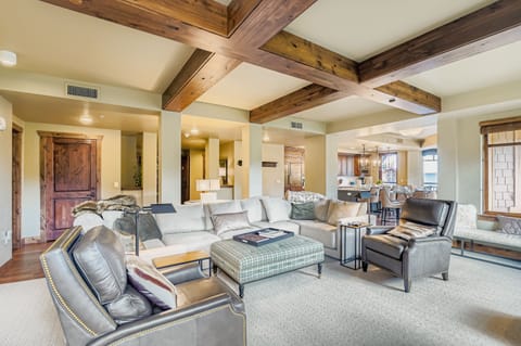 Relax in this stunning open-concept living area featuring dramatic exposed wood beams, plush sectional seating, and modern decor. The perfect gathering space for cozy evenings and mountain-town memories.