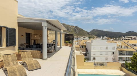 Spacious furnished terrace with lounge area, sunbeds and open views over Port de Pollença and the building’s pool