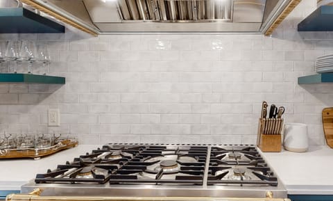 Modern kitchen with a stainless steel gas stove and white subway tile backsplash