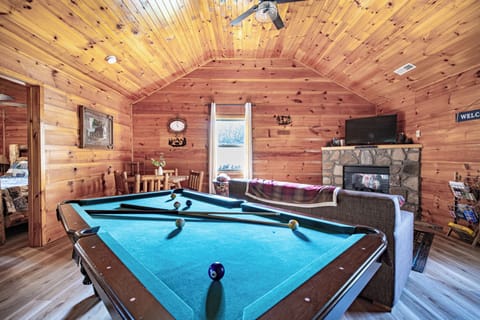 Cabin comfort meets game night—pool table, fireplace, and warm wood vibes.