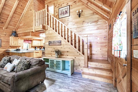 Admire the craftsmanship of this cozy retreat featuring a wood-paneled staircase, vintage console table, and warm cabin kitchen—your inviting escape in Pigeon Forge, Tennessee.