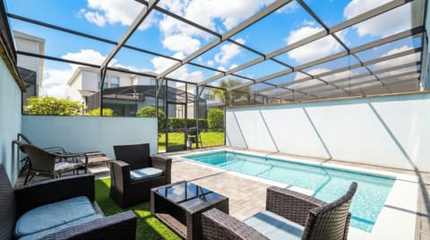 Relax in the private screened pool with stylish outdoor seating under sunny skies.