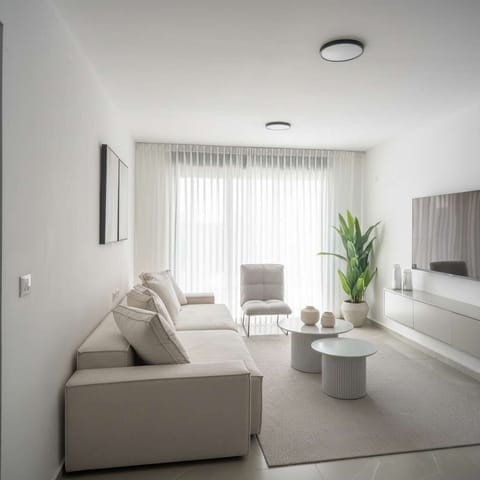 Bright minimalist lounge invites slow mornings, soft light filtering through curtains, moments of calm comfort.