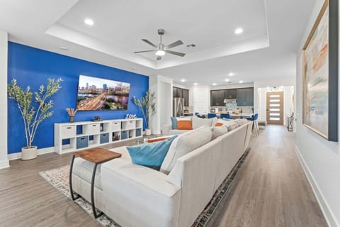 Living room with 85" 4K TV, PS4 and various games, and oversized spacious seating