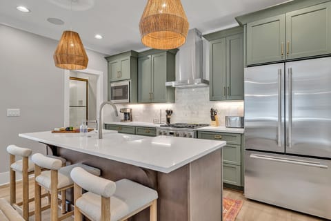 Unit 1 - 2nd Floor: Fully equipped kitchen stocked with all culinary essentials featuring stainless-steel appliances and a kitchen island offering ample counter space and bar seating.